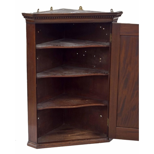 898 - Georgian mahogany hanging corner cupboard, with moulded and carved key cornice over panelled door wi... 