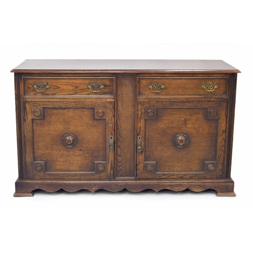 884 - Oak sideboard, the moulded top over two short drawers and two panelled cupboard doors with carved ro... 