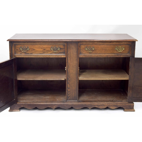 884 - Oak sideboard, the moulded top over two short drawers and two panelled cupboard doors with carved ro... 