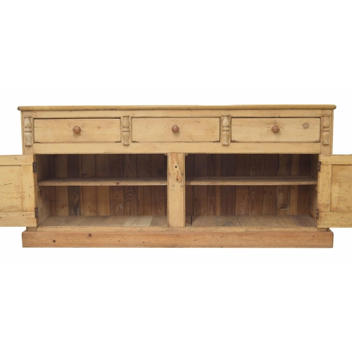 924 - Large Victorian stripped pine farmhouse dresser base, the plain top over three short drawers above t... 