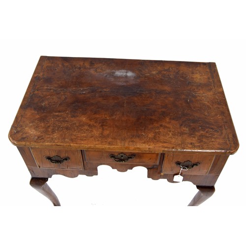 873 - Georgian walnut low boy, the quarter veneered top over three short drawers and shaped frieze raised ... 