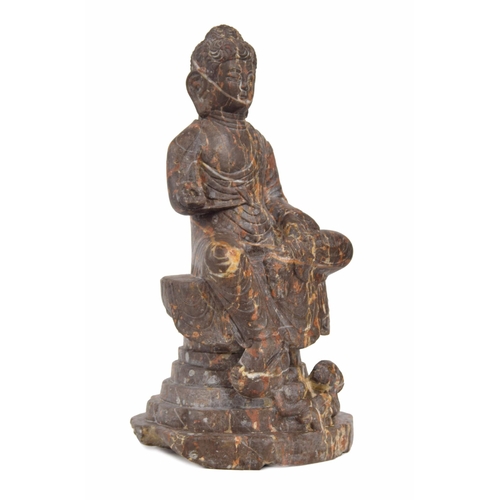 749 - Chinese veined rouge carved marble seated Buddha figure, modelled upon a stepped circular plinth, 15... 