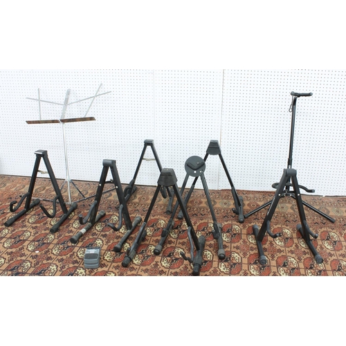 1152 - Eight various guitar stands, a music ledge and a Behringer chromatic tuner guitar pedal... 