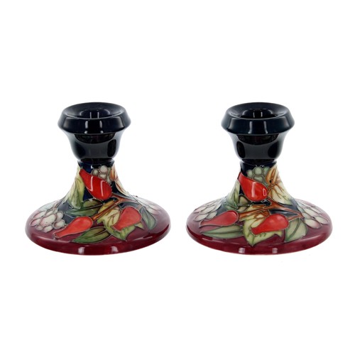 606 - Pair of Moorcroft Pottery 'Winter Harvest' squat candlesticks designed by Sian Leeper, circa 2003, w... 