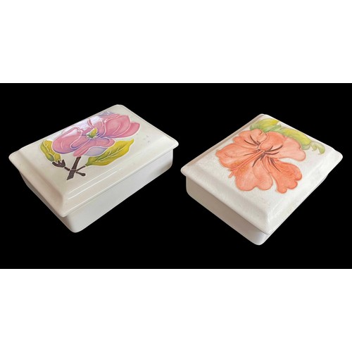 600 - Two Moorcroft Pottery 'Hibiscus' rectangular trinket boxes with covers, decorated on a pale ground, ... 