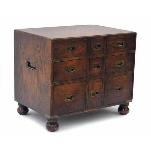 850 - Oak campaign style chest of drawers of small proportions, with brass bound corners and recessed carr... 