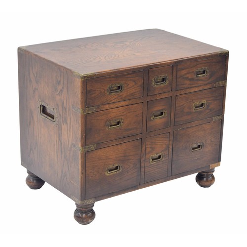 850 - Oak campaign style chest of drawers of small proportions, with brass bound corners and recessed carr... 