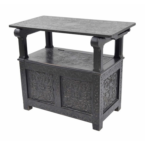 871 - Ebonised carved oak monk's bench, the transitional hinged top over a hinged seat enclosing an open b... 