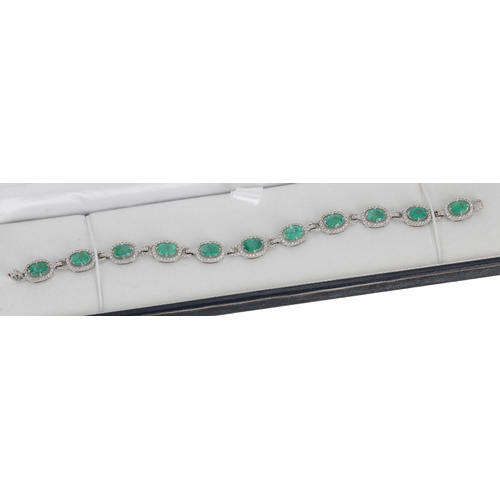 120 - Modern attractive 18ct white gold emerald and diamond line bracelet, oval emeralds 7.12ct total, dia... 