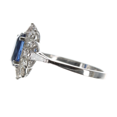 205 - Good quality 18ct white gold ring set with an oval sapphire surrounded by a halo of round brilliant ... 