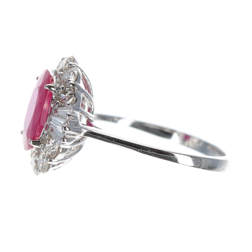 215 - 18ct white gold ring set with oval ruby, surrounded by a halo of round brilliant cut and tapered bag... 