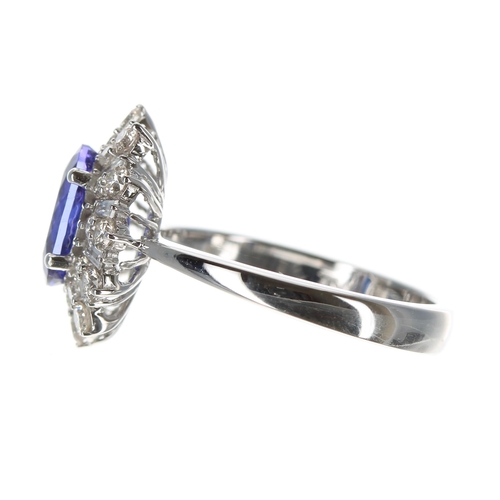 225 - Attractive modern 18ct white gold ring set with an oval tanzanite surrounded by round brilliant cut ... 