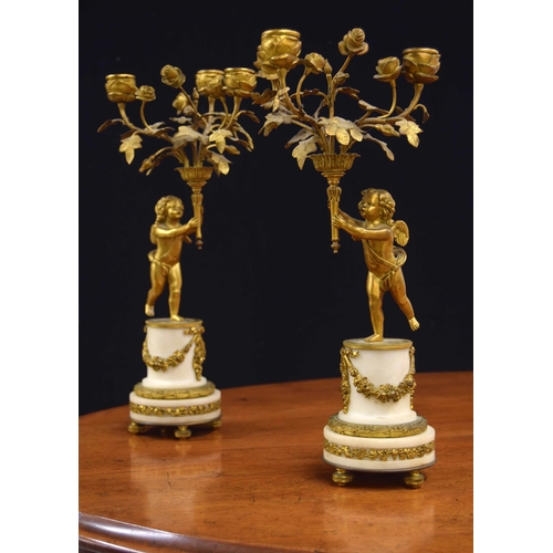 578 - Pair of Louis XVI style gilt metal and white marble figural candelabra, modelled as putto holding  a... 