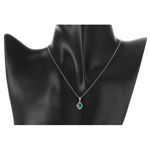 236 - Attractive 18ct white gold emerald and diamond cluster pendant on a slender chain, the oval emerald ... 