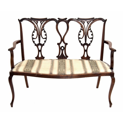 761 - Mahogany double chair back settee, with carved stylised open splats, over a stuff over bench seat on... 