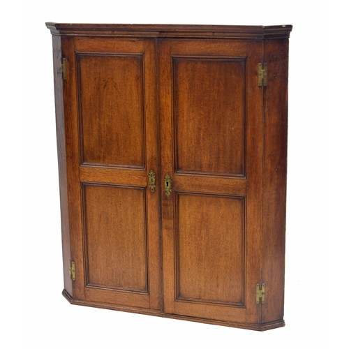 769 - 19th century oak corner cupboard, with two panelled doors enclosing a shelved interior, 36