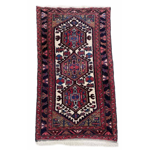 751 - Small Afghan Heriz type rug, on a red ground, 53