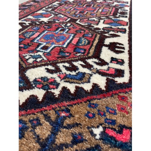 751 - Small Afghan Heriz type rug, on a red ground, 53