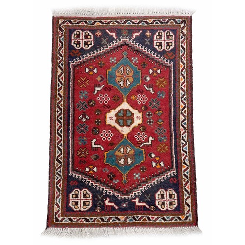 752 - Small Persian rug on a red ground, 40