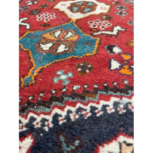 752 - Small Persian rug on a red ground, 40