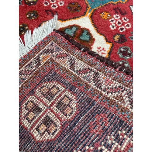 752 - Small Persian rug on a red ground, 40