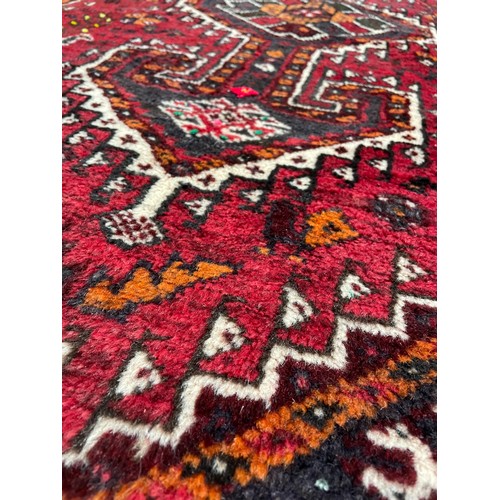 753 - Iranian handmade Shiraz rug, labelled, on a dark red ground, 70