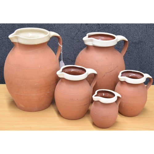 4 - Graduated set of four Royal Barum Ware terracotta jugs, largest 9.5