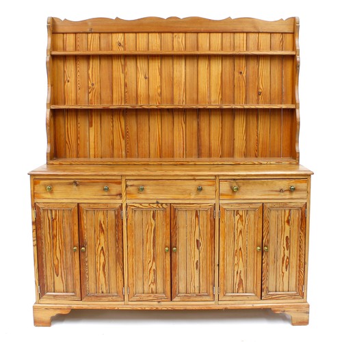 1182 - Tony Zemaitis - a large pitch pine dresser, with three tier panelled delft rack over three short dra... 