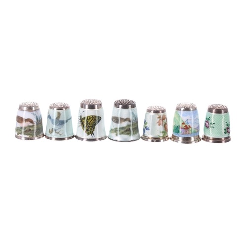 816 - Collection of seven modern silver and guilloché enamel thimbles, detailing birds, a butterfly, flora... 