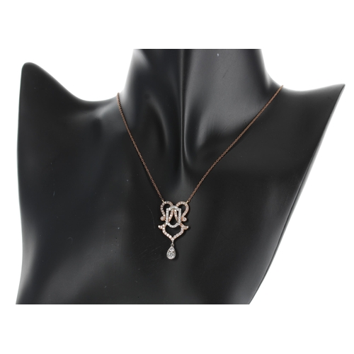 630 - Ornate two colour diamond set drop pendant on a gilded rose coloured necklace, 3.92g, the pendant dr... 