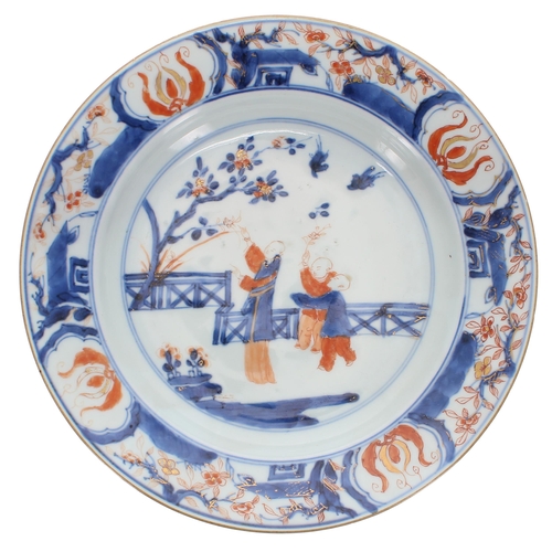 261 - Chinese porcelain shallow dish, in underglaze blue and iron-red depicting three tree pickers with gi... 