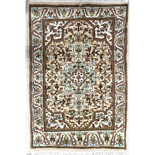 473 - Small Kashmir pattern rug, with a central floral medallion on a natural ground, 40