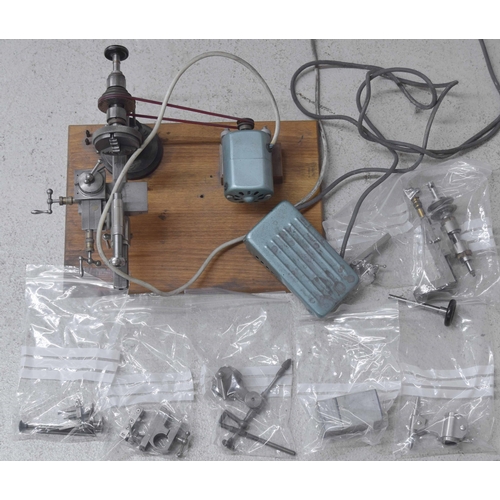 2114 - Small electric clock/watchmakers lathe with various attachments and accessories, mounted onto a wood... 