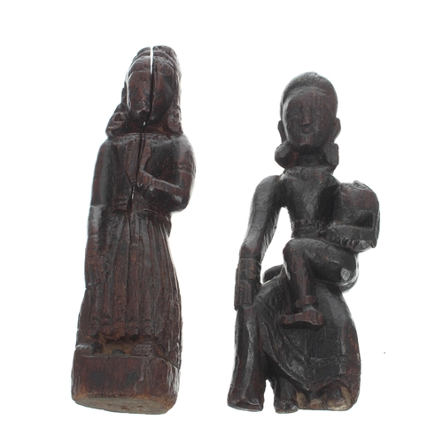 791 - Two Southern Indian carved treen figures of ladies, one sat with a child on her knee, the other stan... 