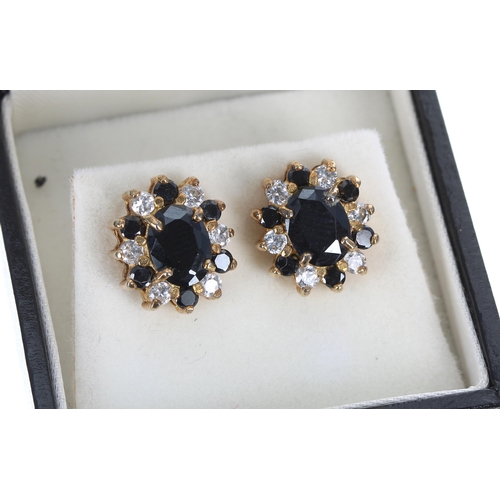 158 - Pair of 18ct yellow gold sapphire and diamond oval cluster earrings, with a border of round brillian... 