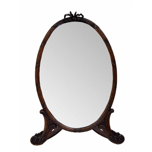 1012 - Mahogany oval strut dressing mirror, the plain glass within a reeded frame surmounted by a carved bo... 