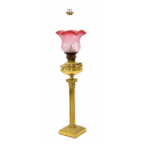 779 - Victorian brass Corinthian column oil lamp, with a graduated cranberry etched glass shade... 