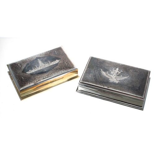 852 - Two similar Thai white metal cigarette boxes, with Niello type decorated covers with buildings and a... 