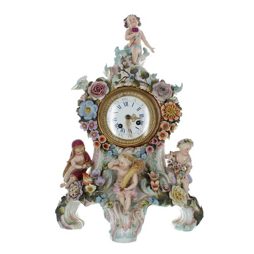 Attractive Sitzendorf porcelain mantel clock, the case with four putti figures representing the seasons, with floral encrusted decoration on three scroll feet, bearing a blue baton mark to the underside, 19" high (with pendulum and winding key)