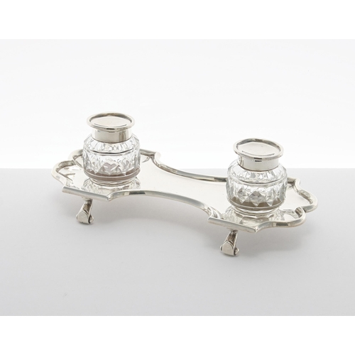 502 - Late Victorian silver desk inkstand, the shaped and lobed stand raised on four scroll feet with two ... 