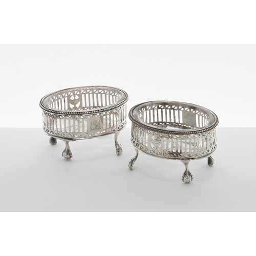 507 - Pair of Georgian silver open salts, the pierced oval baskets raised on four claw and ball feet enclo... 