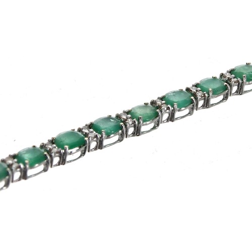 348 - Modern 18ct white gold line bracelet, set with emeralds and diamonds with an open box clasp and doub... 