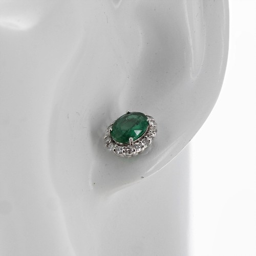 8 - Pair of certificated 18ct white gold oval emerald and diamond cluster stud earrings, the emeralds 3.... 