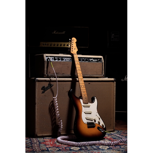 1957 Fender Stratocaster electric guitar, made in USA; Body: two-tone sunburst finish, checking throughout, scratching and finish rubbing to edges and back as to be expected for a used guitar of this age; Neck: maple, light wear patches and minor dings; Fretboard: wear throughout; Frets: wear, including indents up to the twelfth fret, although still very playable, replacement nut with remnants of an old nut within the case; Electrics: working and appear original, light crackle on volume pot function; Hardware: generally good and appears original, splits to corners of cavity back plate with some plastic loss to one corner, small splits to pickguard beside the uppermost bass side screws, tarnishing to metal hardware; Case: original tweed hard case; Weight: 3.32kg; Overall condition: good for age;