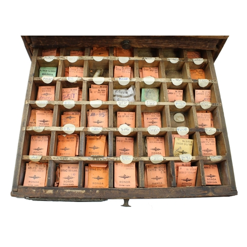 396 - Nine drawer wooden chest containing a quantity of watch parts to include balance staffs, balances an... 