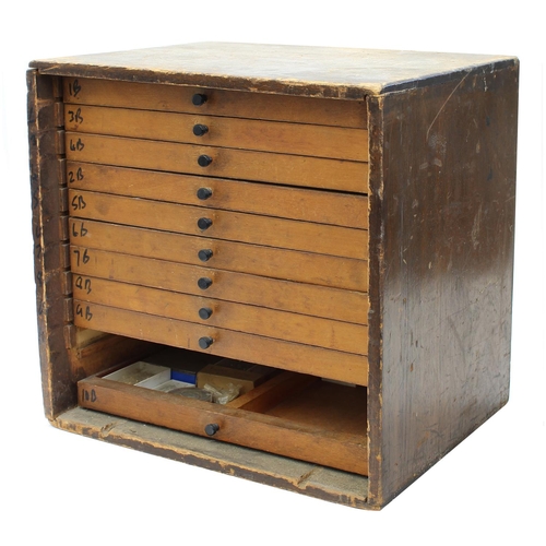 397 - Twelve drawer wooden chest containing a quantity of watch parts including balances, stems, wheels, d... 