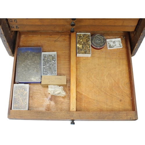 397 - Twelve drawer wooden chest containing a quantity of watch parts including balances, stems, wheels, d... 