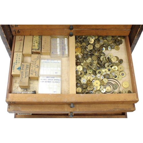 397 - Twelve drawer wooden chest containing a quantity of watch parts including balances, stems, wheels, d... 