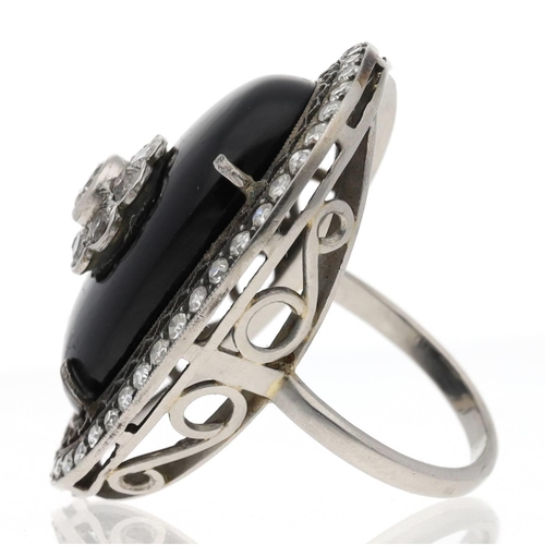 113 - Fancy large oval white metal diamond and black onyx cocktail ring, with a round brilliant-cut diamon... 