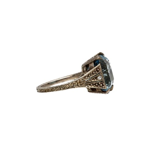 79 - White metal patterned mount large blue topaz and diamond ring, width 13.5mm, 4.9gm, ring size H/I (3... 